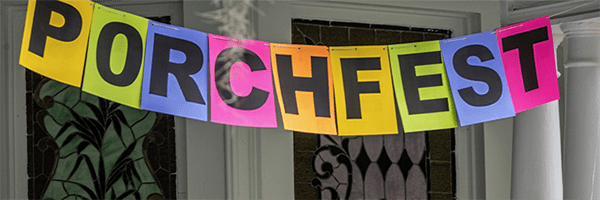 Photo of a Porchfest banner hanging on a porch.
